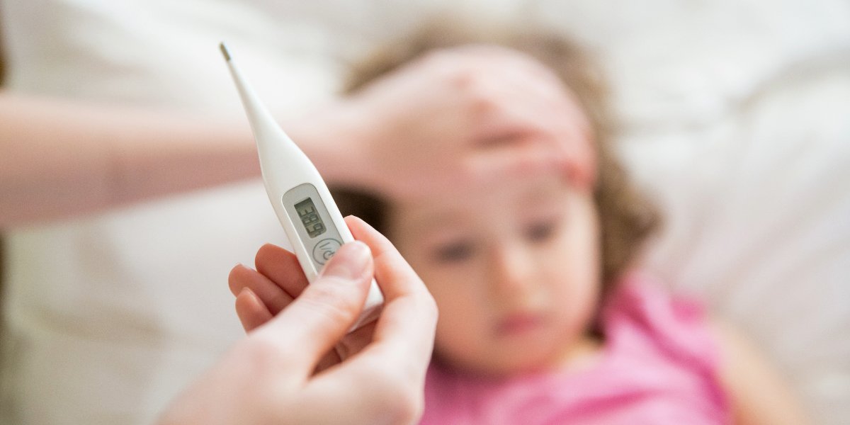 Someone taking the temperature of a child.