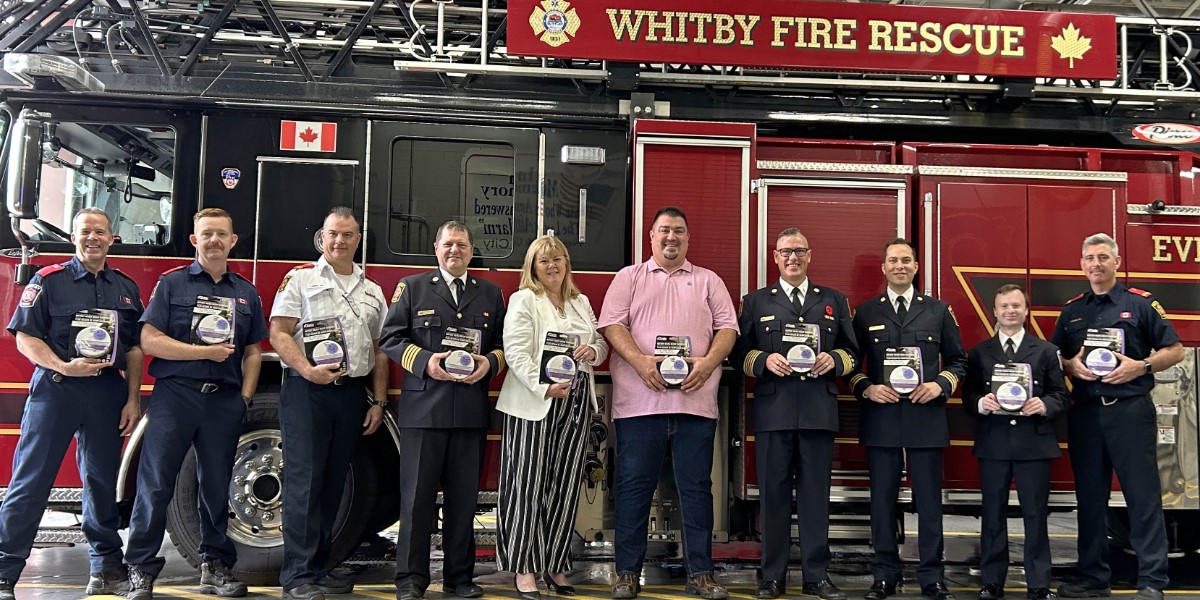 Mayor Roy and members of Whitby Fire and Emergency Services standing in a row in front of a fire truck