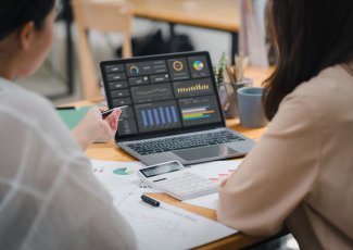 Two people looking at stats on a computer