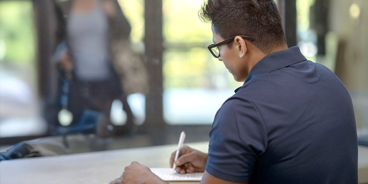 A person sitting at a desk writing out a receipt