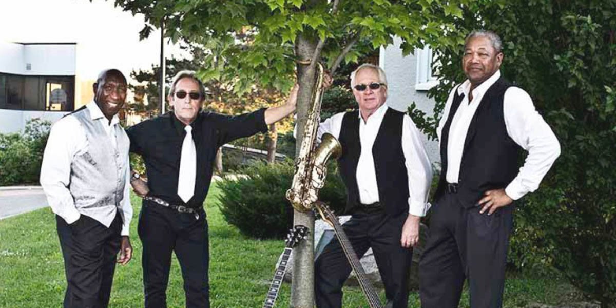 Andy Earle and the Bandits standing in a park with instruments
